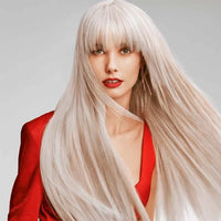 Thumbnail for A woman with long, straight platinum blonde hair and straight bangs, wearing a bright red top against a light gray studio background.