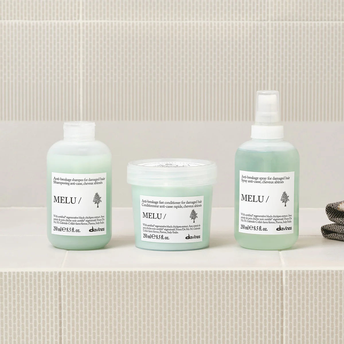 Three bottles of Melu hair care products on a bathroom counter.