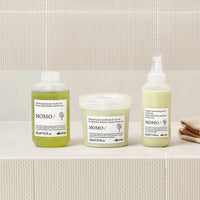 Thumbnail for Three Momo hair care products on a bathroom counter with a tiled wall background.