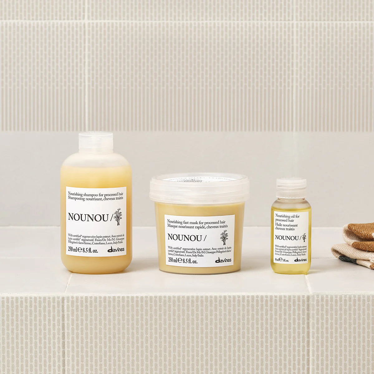 Three NOUNOU hair care products on a white surface with a neutral background