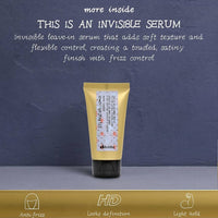 Thumbnail for A squeeze tube of hair serum with a pale yellow body and black cap, standing upright against a textured dark blue-gray background. White text at the top reads 'THIS IS AN INVISIBLE SERUM' with descriptive copy about adding soft texture and frizz control.