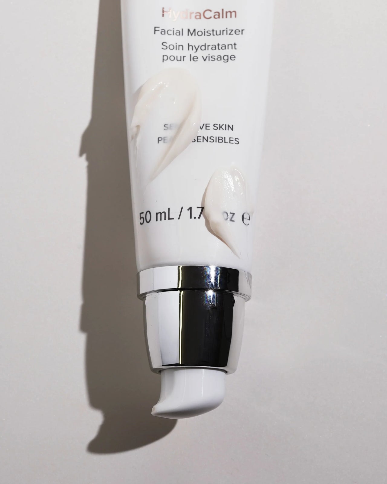 A squeeze tube of HydraCalm Facial Moisturizer with a metallic silver pump, shown against a light gray background with a soft shadow.