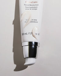 Thumbnail for A squeeze tube of HydraCalm Facial Moisturizer with a metallic silver pump, shown against a light gray background with a soft shadow.