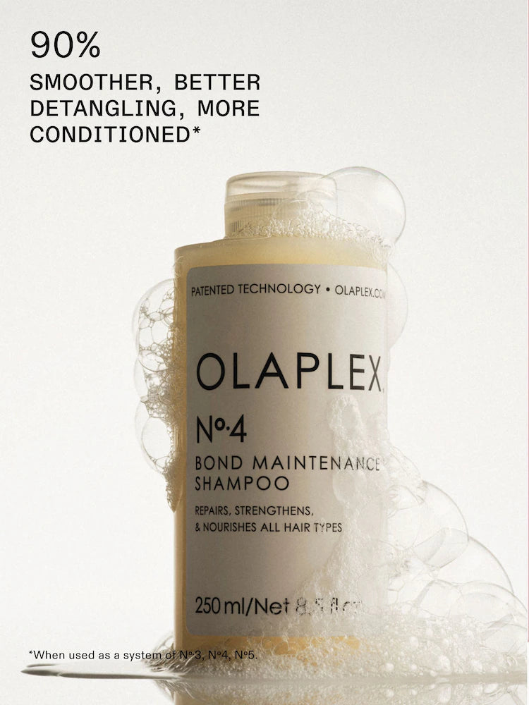 A bottle of Olaplex No.4 Bond Maintenance Shampoo centered on a light background with floating bubbles around it and promotional text at the top reading '90% SMOOTHER, BETTER DETANGLING, MORE CONDITIONED'.