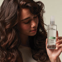 Thumbnail for Woman holding a bottle of Paul Mitchell Super Skinny Serum with a neutral background