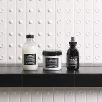 Thumbnail for Three Davines hair care products on a black surface with a white tiled wall background