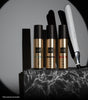 Thumbnail for ghd hair care products including bottles and a flat iron on a marble surface with a gray background.