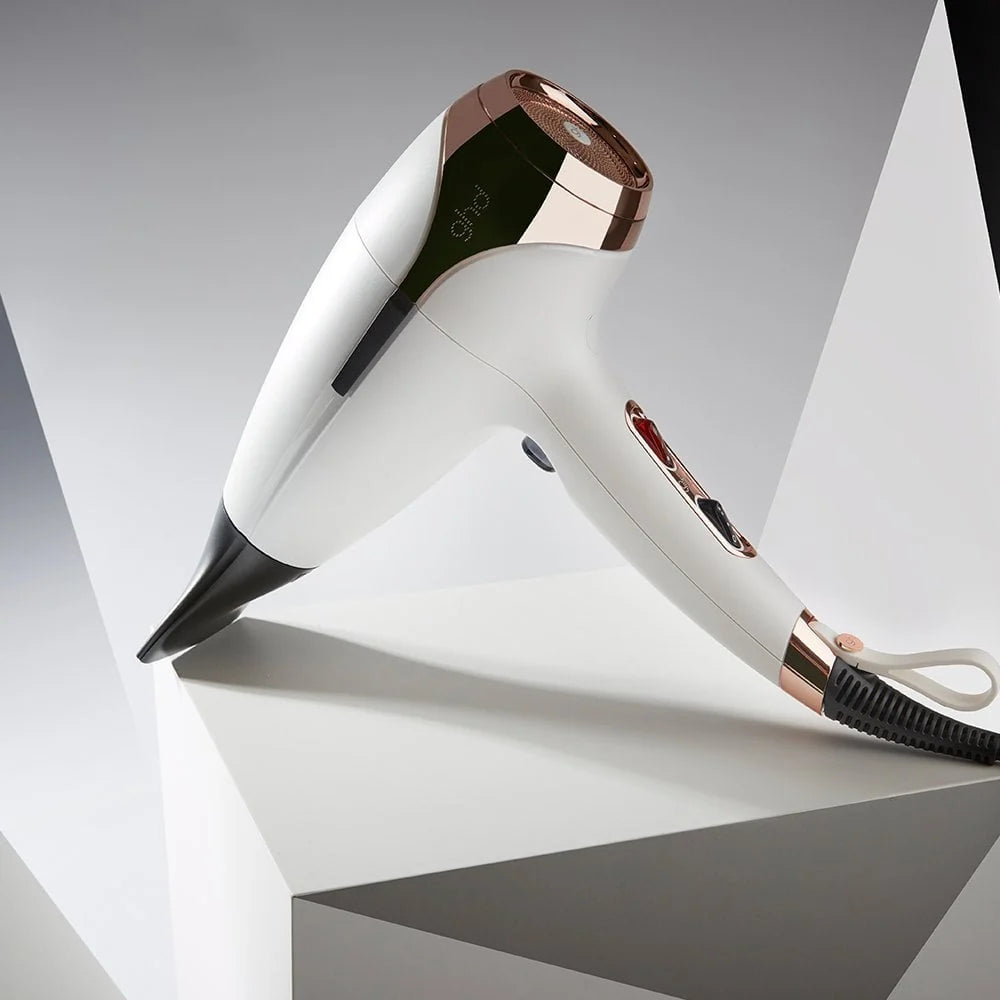 White and rose gold hair dryer on a geometric gray and white background