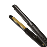 Thumbnail for A close-up studio shot of a black hair straightener with gold-colored heating plates, shown partially open against a solid white background.