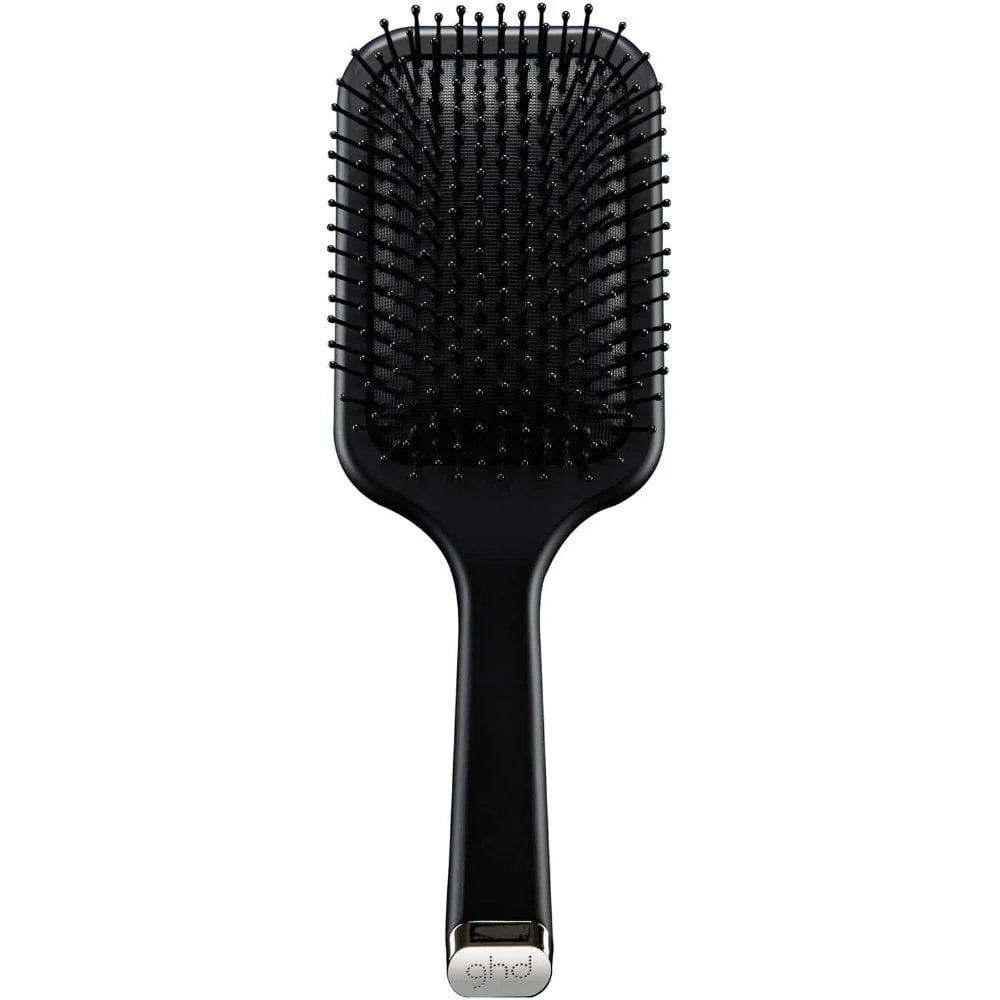 A black paddle hairbrush with flexible bristles and a silver metal accent at the base of the handle, shown against a plain white background.
