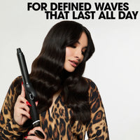 Thumbnail for Woman with styled hair holding a curling iron against a light background