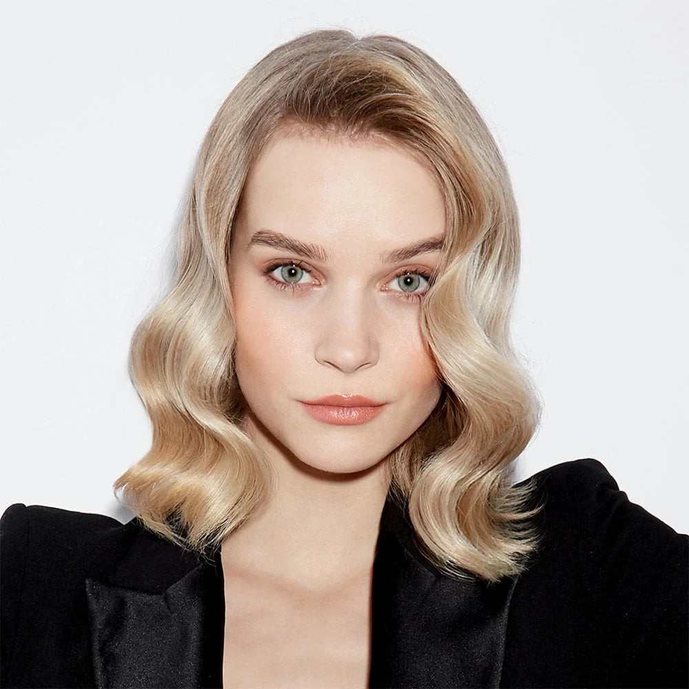 Woman with blonde hair and a black jacket on a white background